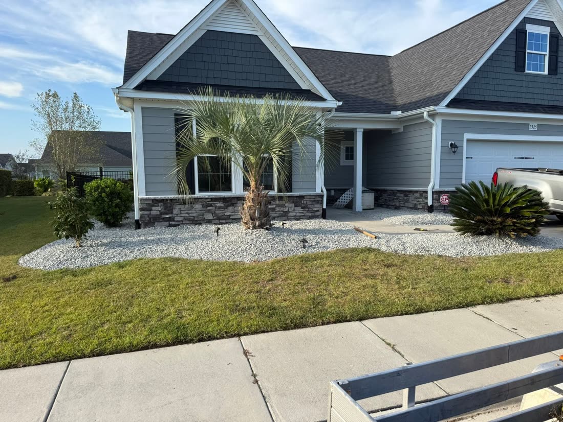 New rock bed and palmetto out front of a home
