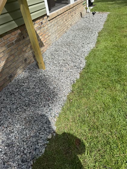 Gravel French drain along a brick foundation