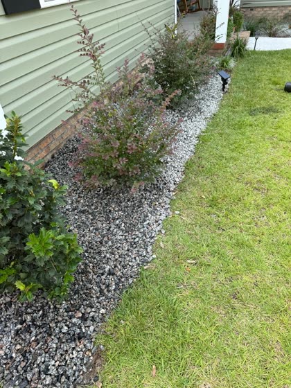 Gravel border with shrubs along a home