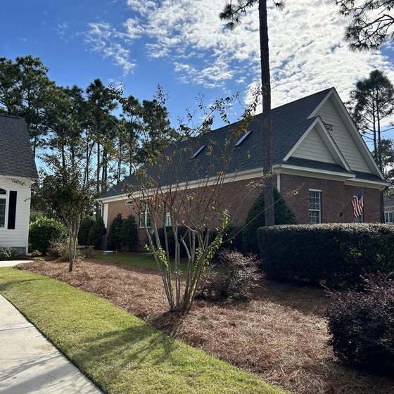 Fresh mulch beds and crepe myrtles at a brick home
