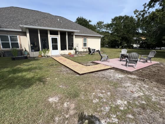 Paver patio with chairs behind a home