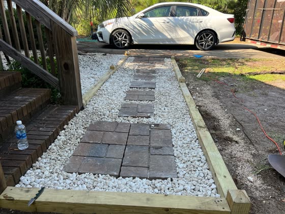 Paver stepping path with white rock and a timber border