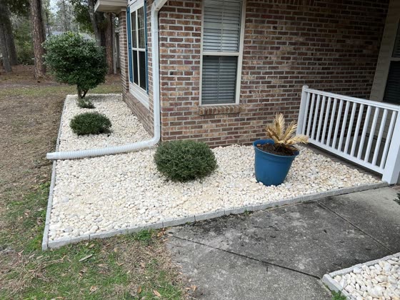 Rock bed and planters at a brick home porch