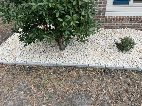 Rock bed around a shrub at a brick home