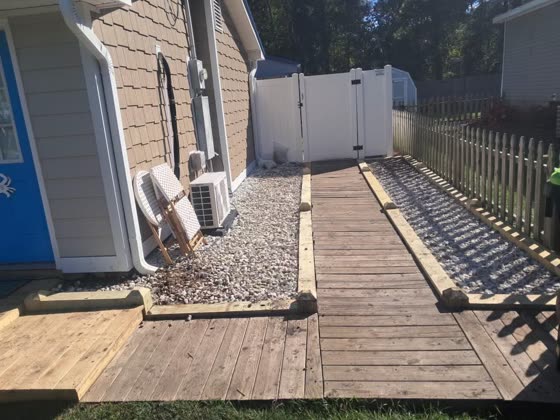 Wood walkway with gravel in a side yard